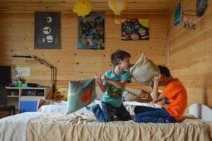 Children having a pillow fight on bed