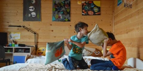 Children having a pillow fight on bed