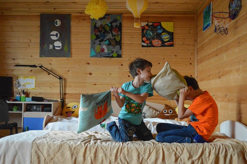 Children having a pillow fight on bed